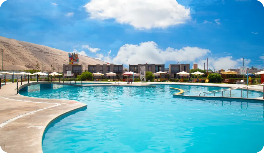 Piscina principal de Touricamp con bungalows y duna al fondo